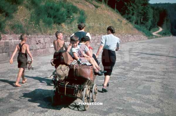A German displaced family moving their last possessions with a wooden wagon. Mother and daughter pull. Silesia 1945