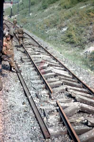 American GI soldiers examining a destroyed railway track near Worms Germany 1945. Rails are destroyed from the Nero order
