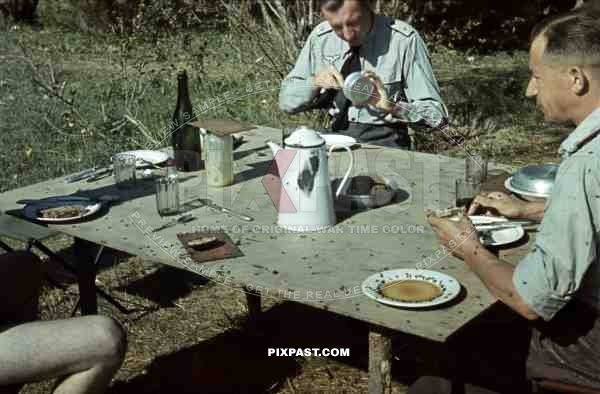 Luftwaffe ground unit officers in summer tunics, Russia summer 1942, eating lunch with bread coffee and flies.