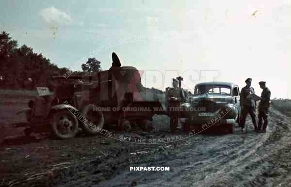 Opel Kapitan saloon car beside destroyed captured Russian BA-10 soviet armoured car Ukraine 1942