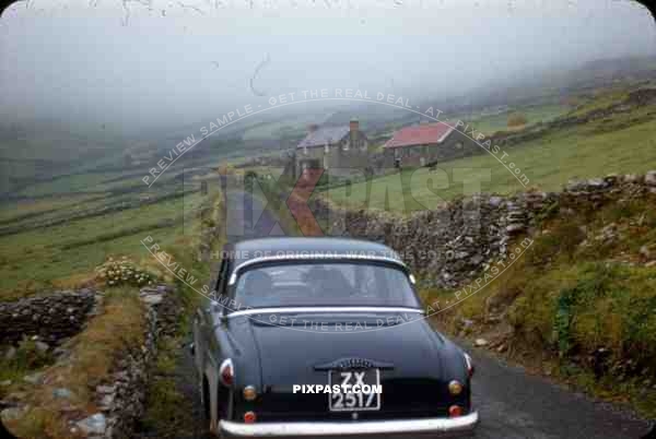 Wicklow Gap Ireland 1953, old timer vintage car in country roads, stone walls and house