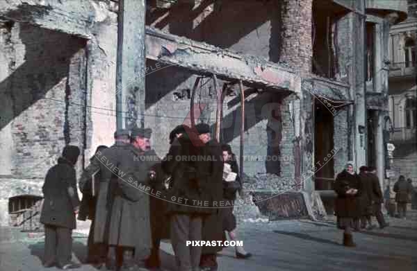 WW2 Color Poland Krakow 1940 German soldiers talk with civilians Bombed Destroyed City Buildings sign posts