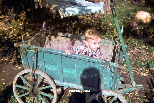 Little boy playing in his blue Bollerwagen in Munich Bavaria Germany 1940