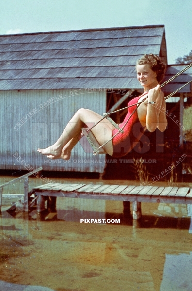 Young German Bavarian women in red swimsuit playing on Swing in Chiemsee Lake Bavaria 1939
